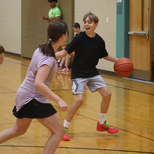 After School Rec photo of boy and girl playing basketball indoors
