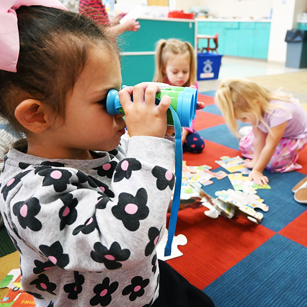 Young girl looking through binoculars
