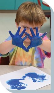 Photo of young child playing with paint